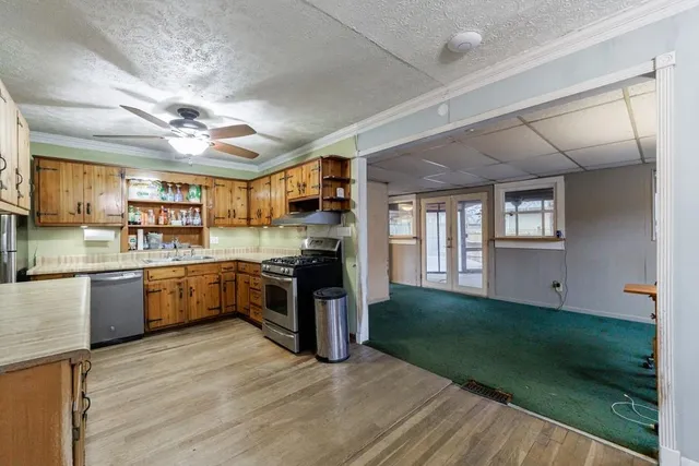 a large kitchen with kitchen island a large counter space a sink stainless steel appliances and cabinets