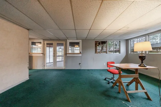 a view of a workspace with furniture and a window
