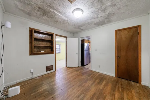 a view of empty room with wooden floor