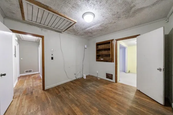 a view of empty room with wooden floor