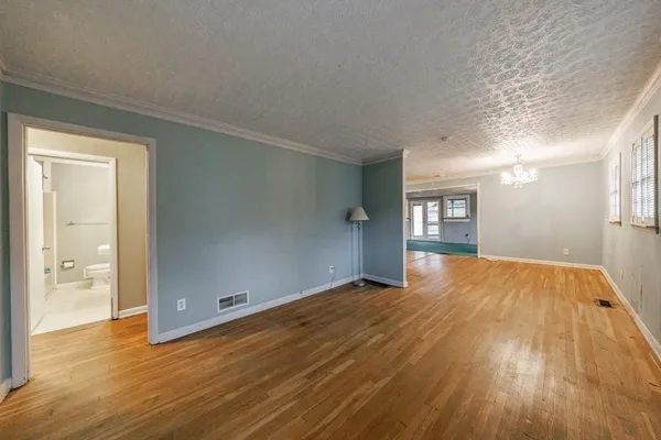a view of empty room with wooden floor and windows