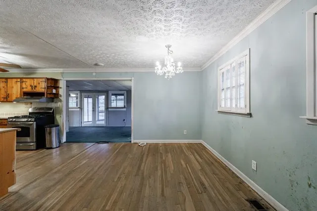 a view of a room with wooden floor and stainless steel appliances
