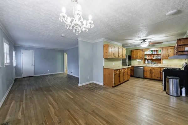 a large kitchen with stainless steel appliances granite countertop a dishwasher and a wooden cabinets
