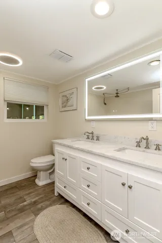a bathroom with a granite countertop toilet sink and mirror
