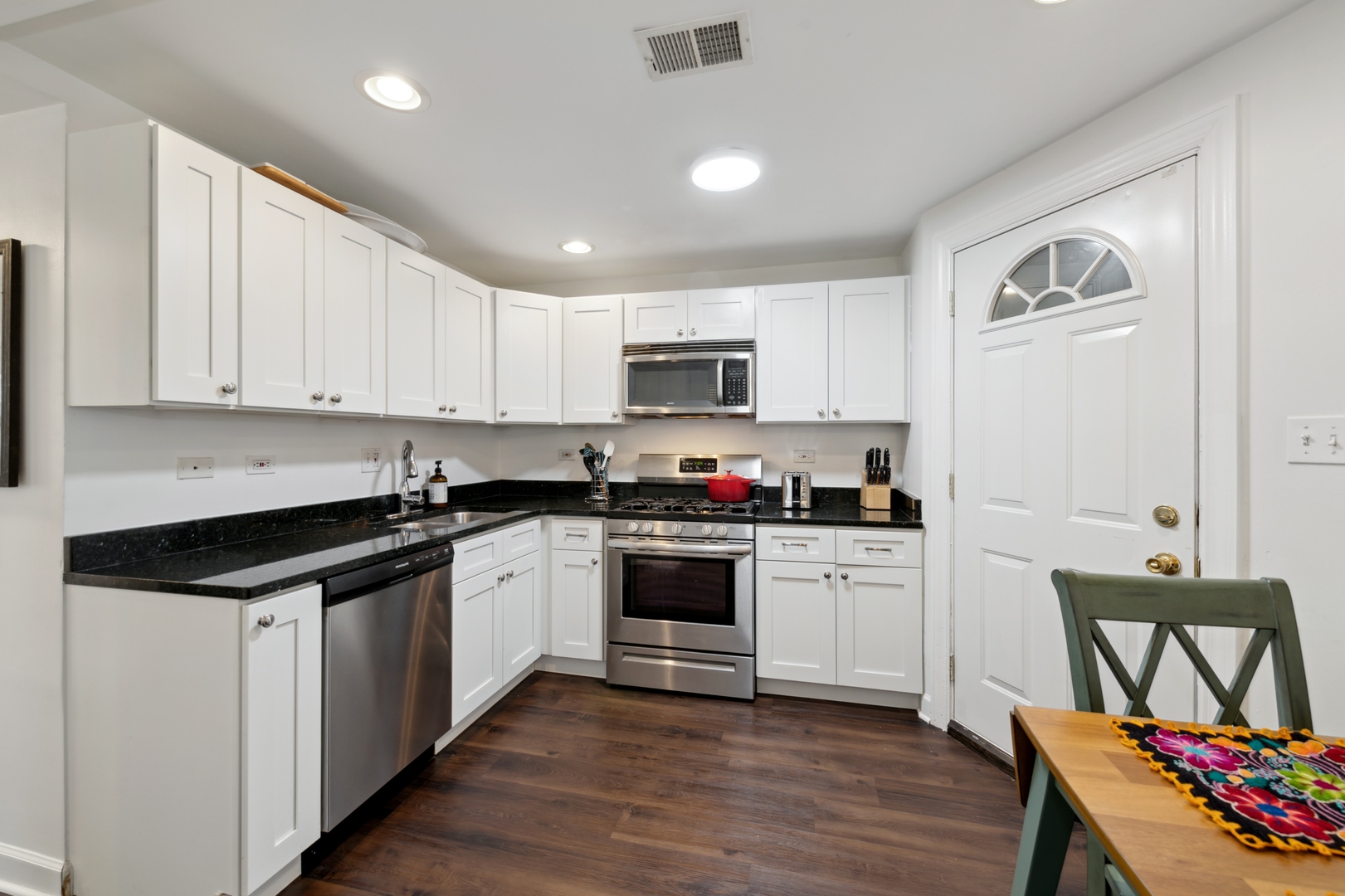 3845 West Altgeld Street, Unit G Chicago, IL 60647 - Photo 6 of 15 a kitchen with granite countertop white cabinets and black appliances