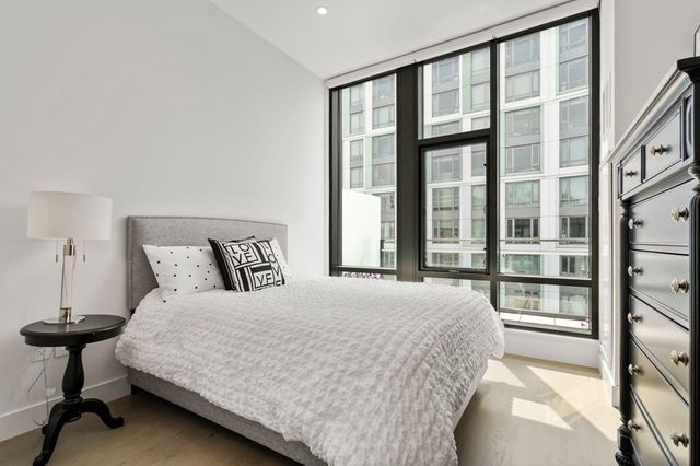 a large bed sitting in a bedroom next to a large window