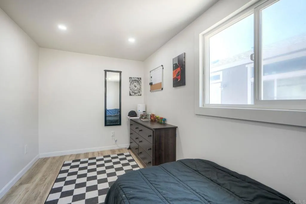 699 North Vulcan Avenue, Unit 6 Encinitas, CA 92024 - Photo 12 of 27 a bedroom with a bed and wooden floor