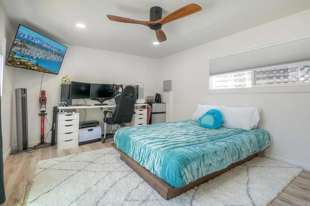 699 North Vulcan Avenue, Unit 6 Encinitas, CA 92024 - Photo 15 of 27 a bedroom with a bed a stove and a flat screen tv