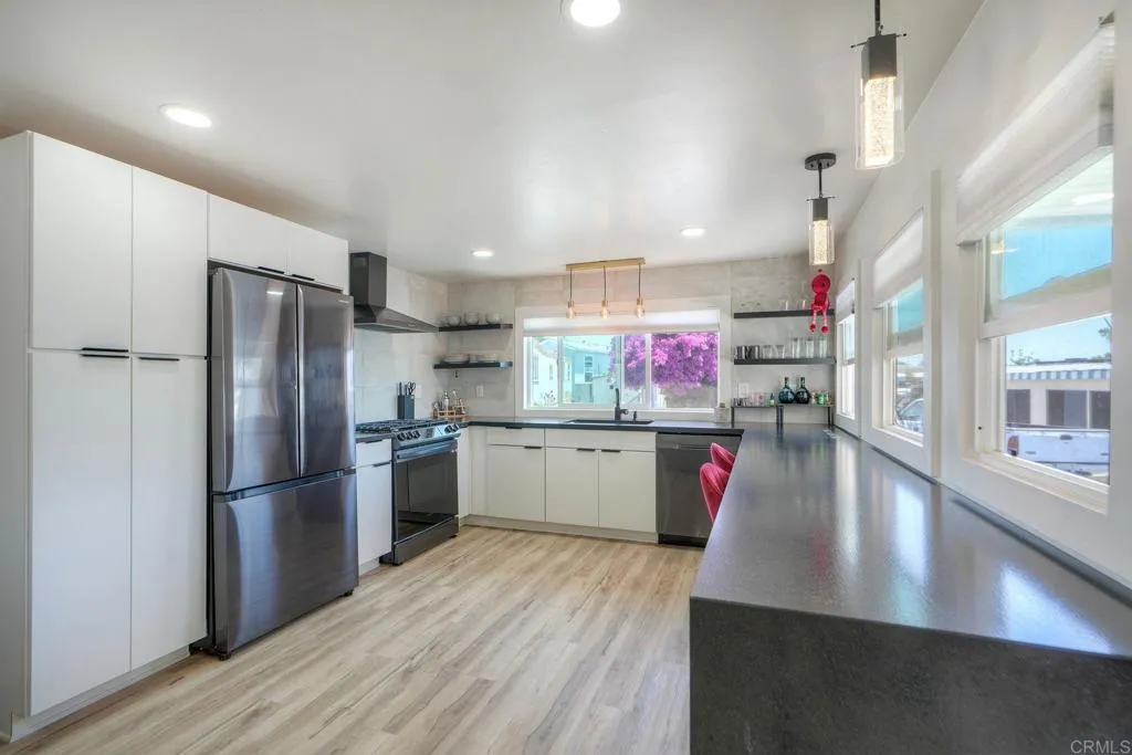 699 North Vulcan Avenue, Unit 6 Encinitas, CA 92024 - Photo 10 of 27 a kitchen with stainless steel appliances granite countertop a refrigerator a sink dishwasher and a stove with wooden floor