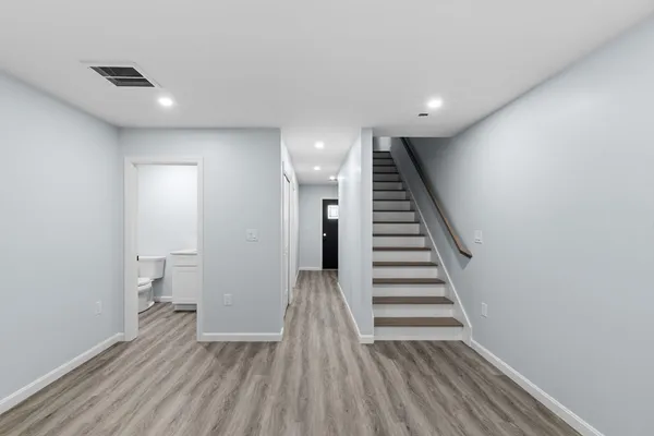 a view of a hallway with wooden floor and stairs