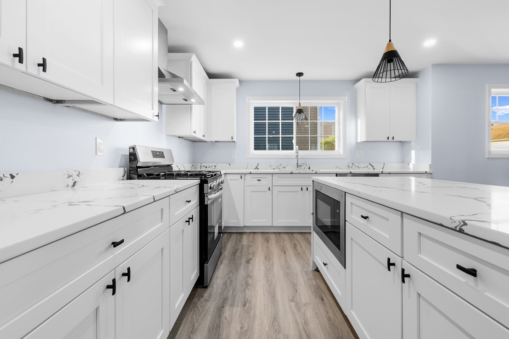 75 Hunter Street Fall River, MA 02721 - Photo 7 of 14 a kitchen with granite countertop a sink stove cabinets and wooden floor