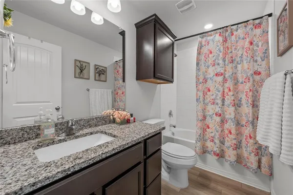 a bathroom with a granite countertop sink toilet and shower