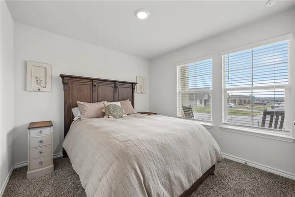 a large bed sitting in a bedroom next to a window