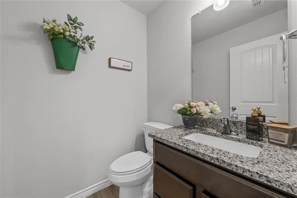 a bathroom with a granite countertop sink a toilet and a mirror