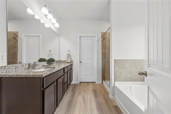 a bathroom with a granite countertop sink a large mirror and a bathtub