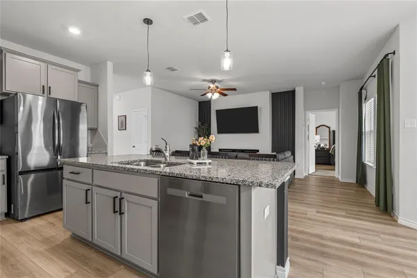 a kitchen with stainless steel appliances granite countertop a sink refrigerator and microwave