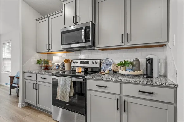 a kitchen with stainless steel appliances granite countertop white cabinets sink and stove