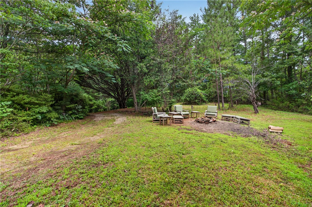 130 Maggie Rufus Lane Westminster, SC 29693 - Photo 39 of 50 A tranquil outdoor fire pit area, surrounded by verdant trees, provides a private space for relaxation.