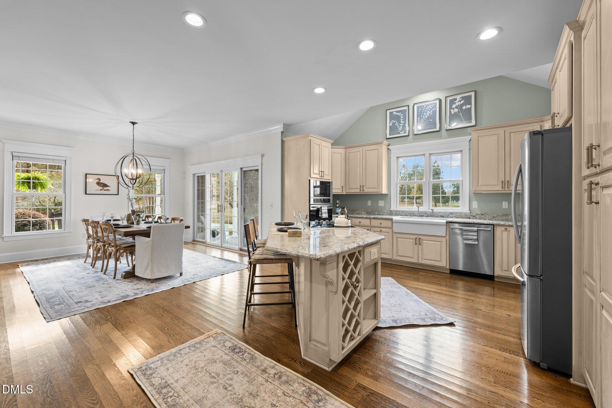 220 Epps Clark Road Siler City, NC 27344 - Photo 27 of 55 a kitchen with stainless steel appliances granite countertop a stove top oven a sink dishwasher a dining table and chairs with wooden floor