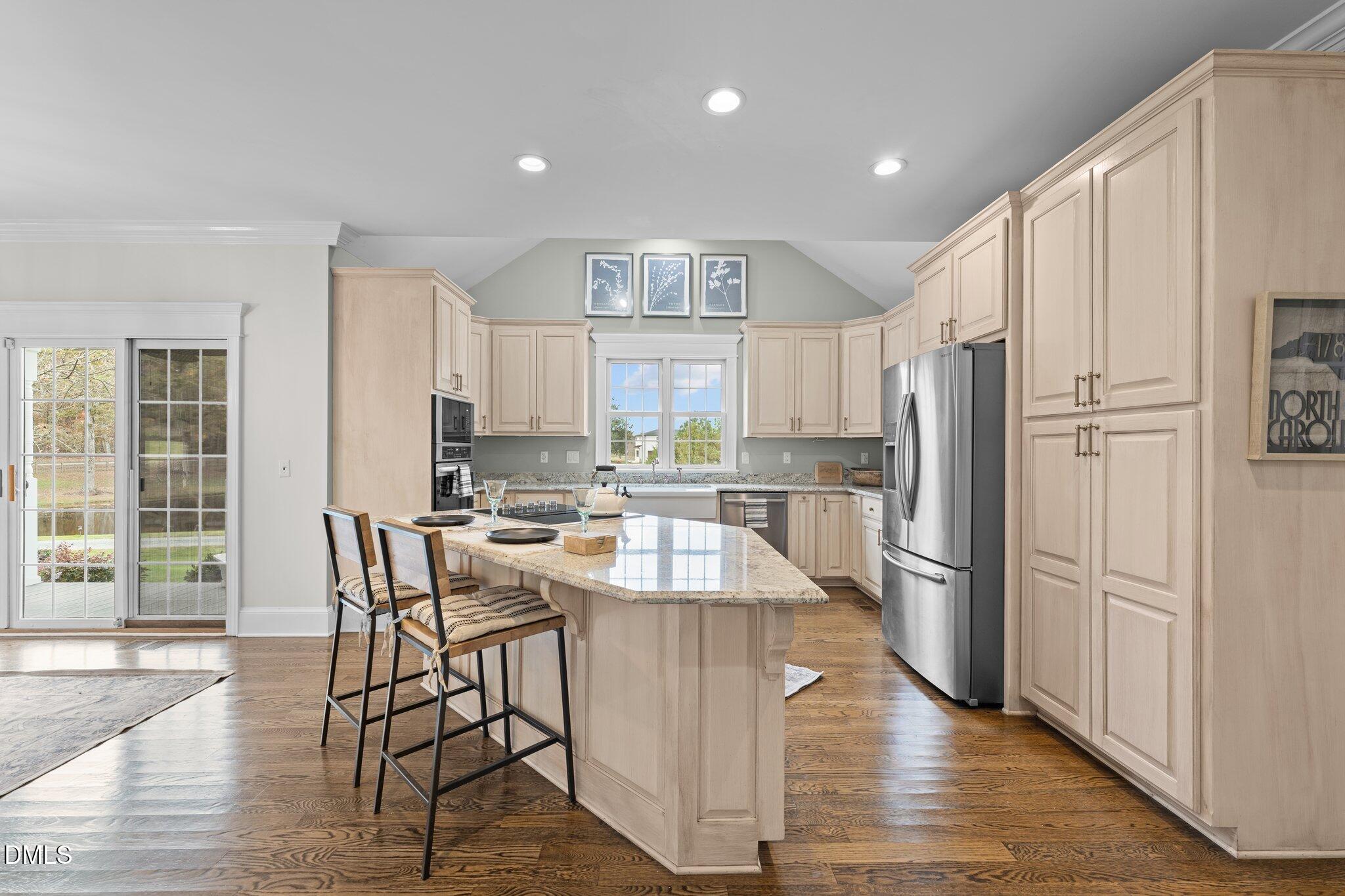 220 Epps Clark Road Siler City, NC 27344 - Photo 28 of 55 a kitchen with kitchen island wooden floors white cabinets and stainless steel appliances