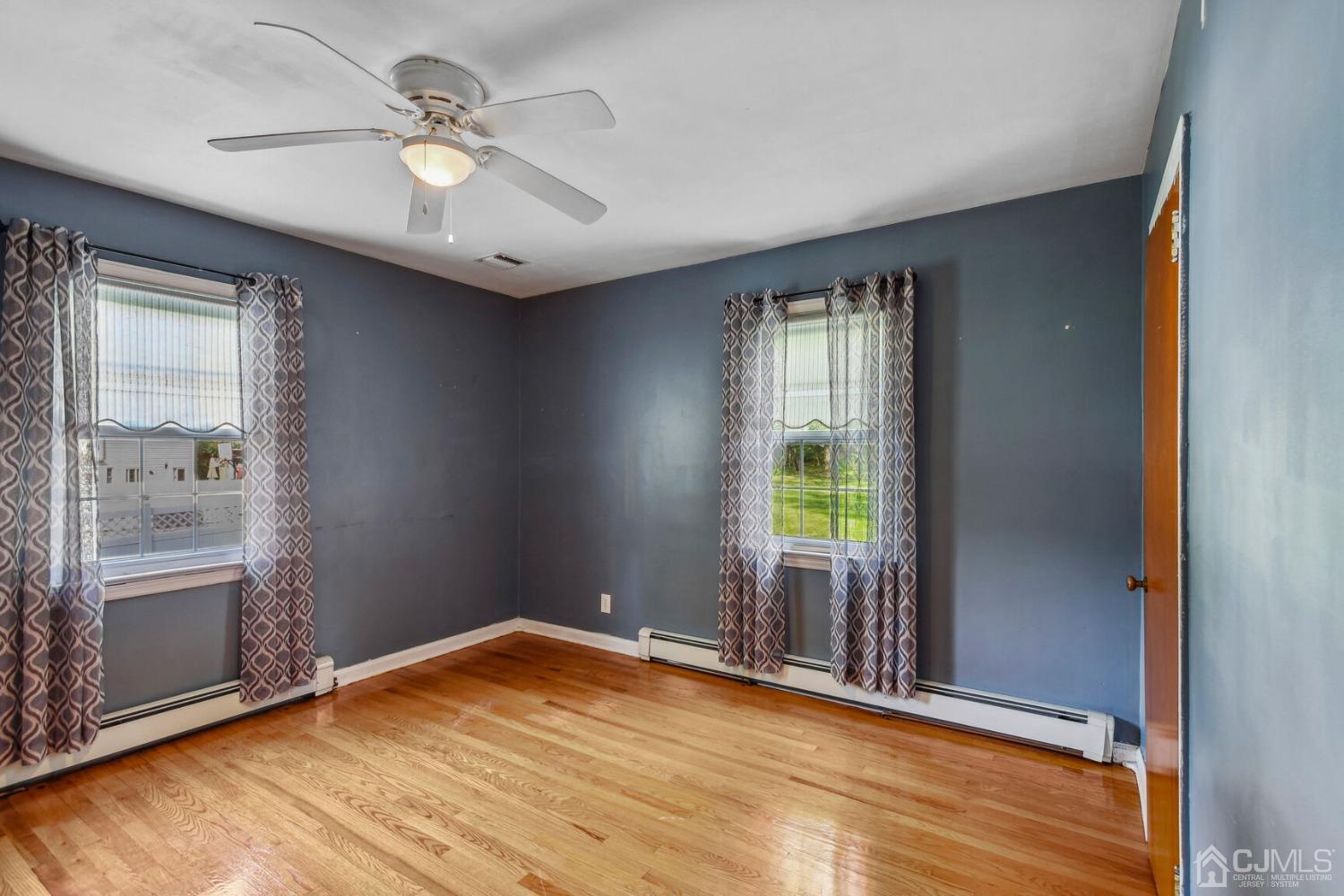 220 Dunhams Corner Road East Brunswick, NJ 08816 - Photo 21 of 27 an empty room with wooden floor fan and windows