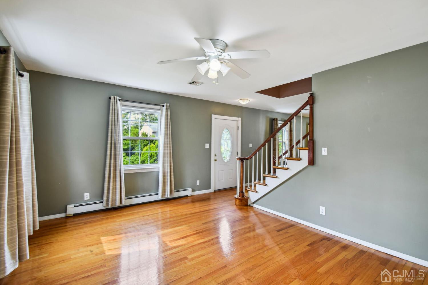 220 Dunhams Corner Road East Brunswick, NJ 08816 - Photo 5 of 27 a view of an empty room with window and wooden floor
