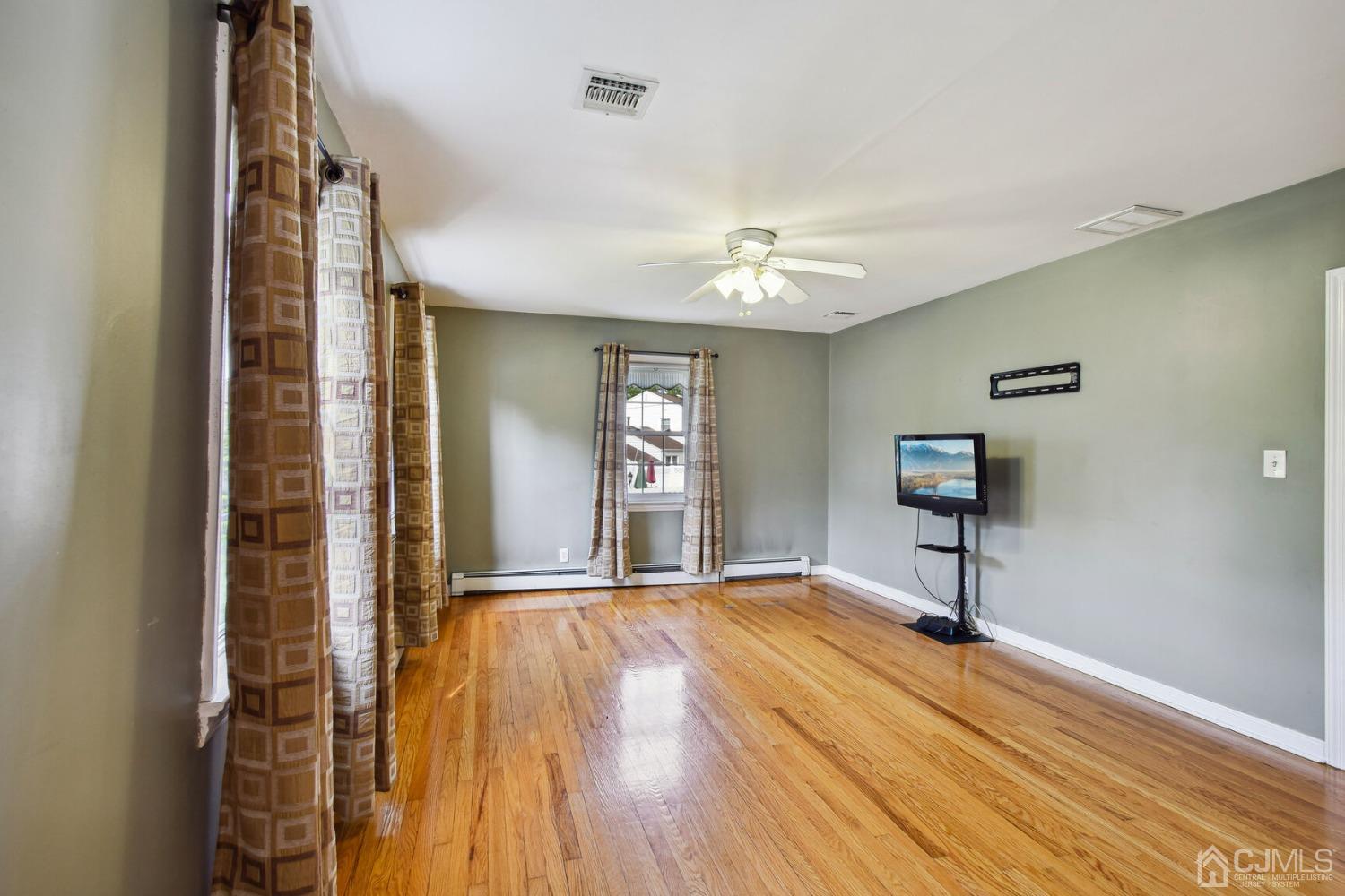 220 Dunhams Corner Road East Brunswick, NJ 08816 - Photo 6 of 27 a view of an empty room with wooden floor and a window
