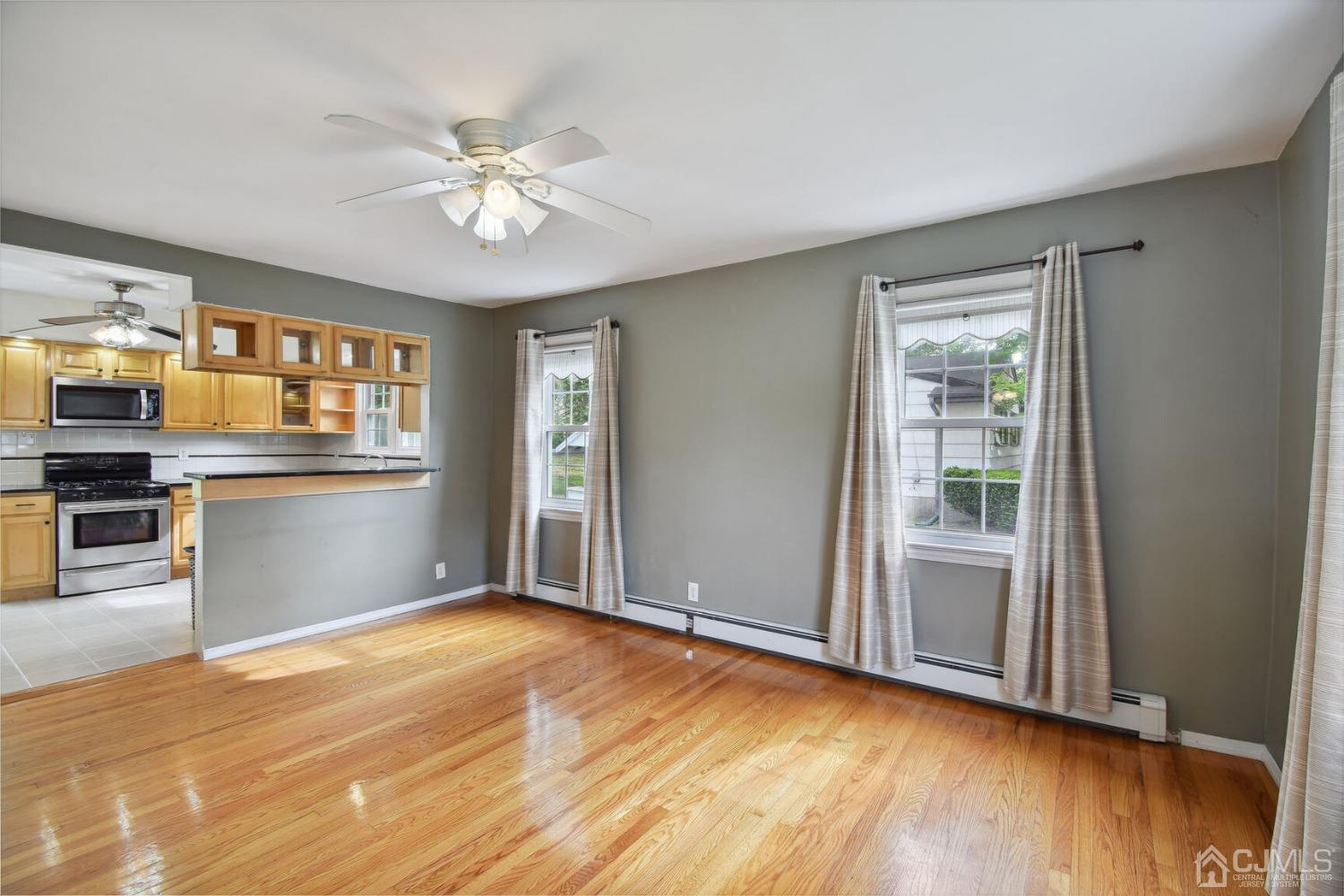 220 Dunhams Corner Road East Brunswick, NJ 08816 - Photo 8 of 27 an empty room with wooden floor kitchen view and windows