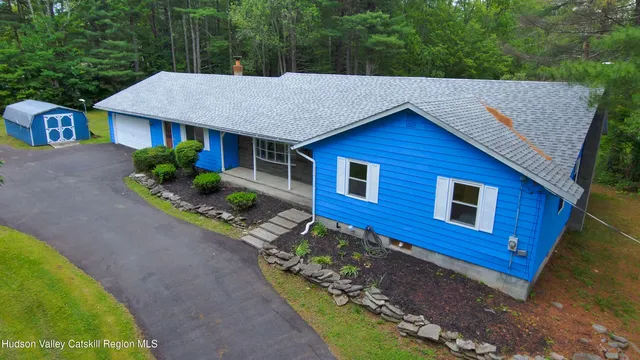 a view of a house with a yard and potted plants