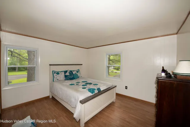 a white bed sitting in a bedroom next to a window