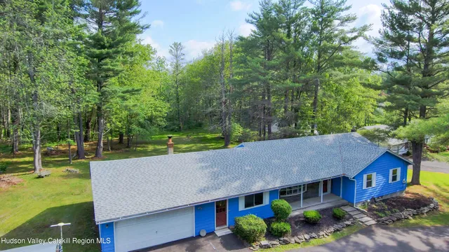 a view of house with garden and tall trees