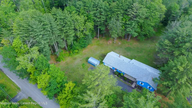an aerial view of a house with a yard lake house swimming pool and outdoor seating
