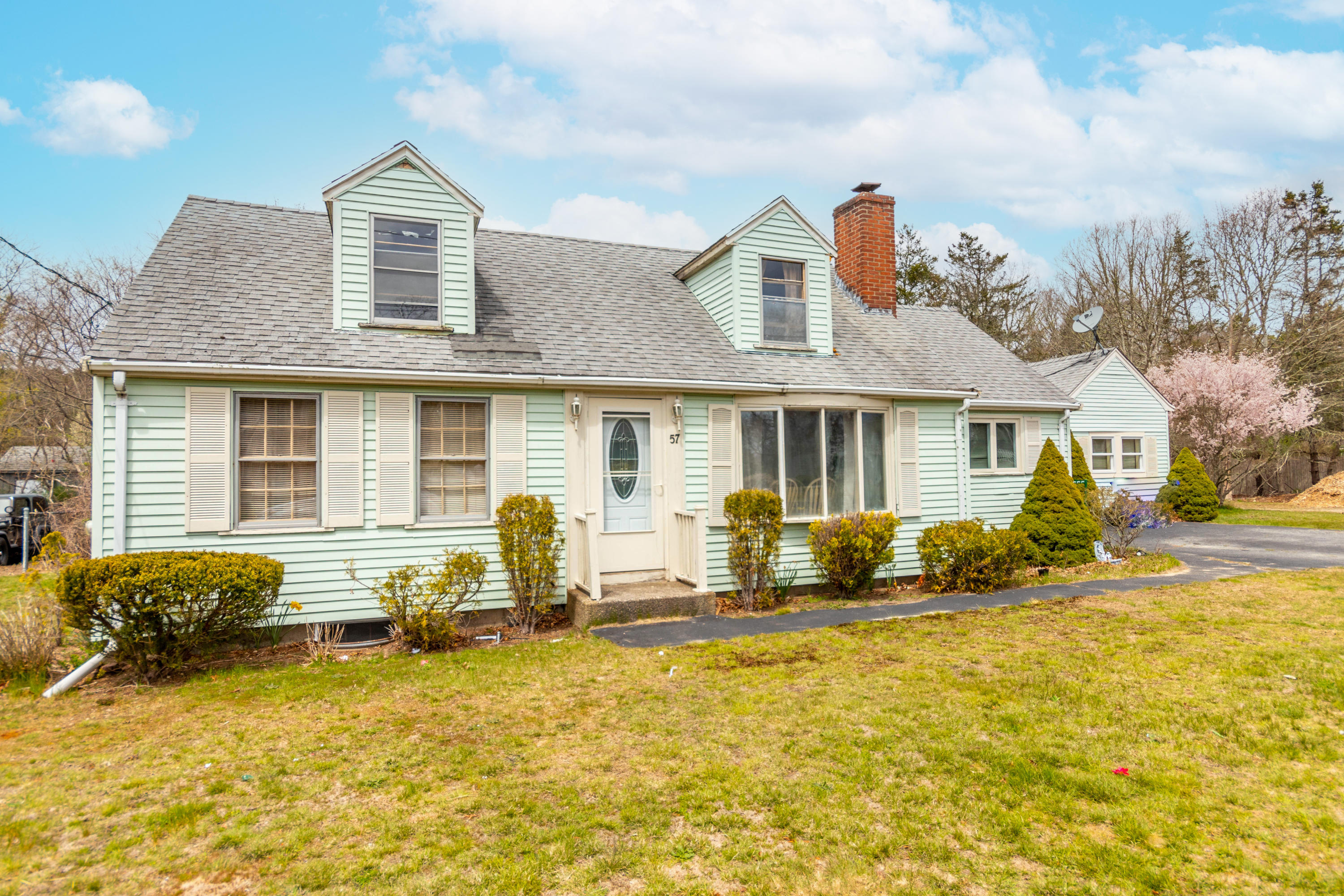 57 Puritan Road Buzzards Bay, MA 02532 - Photo 1 of 27 a front view of house with yard outdoor seating and barbeque oven
