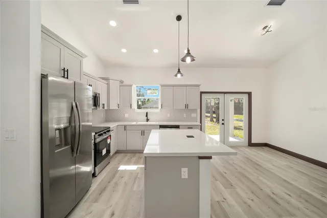 a kitchen with a stove and a wooden floor