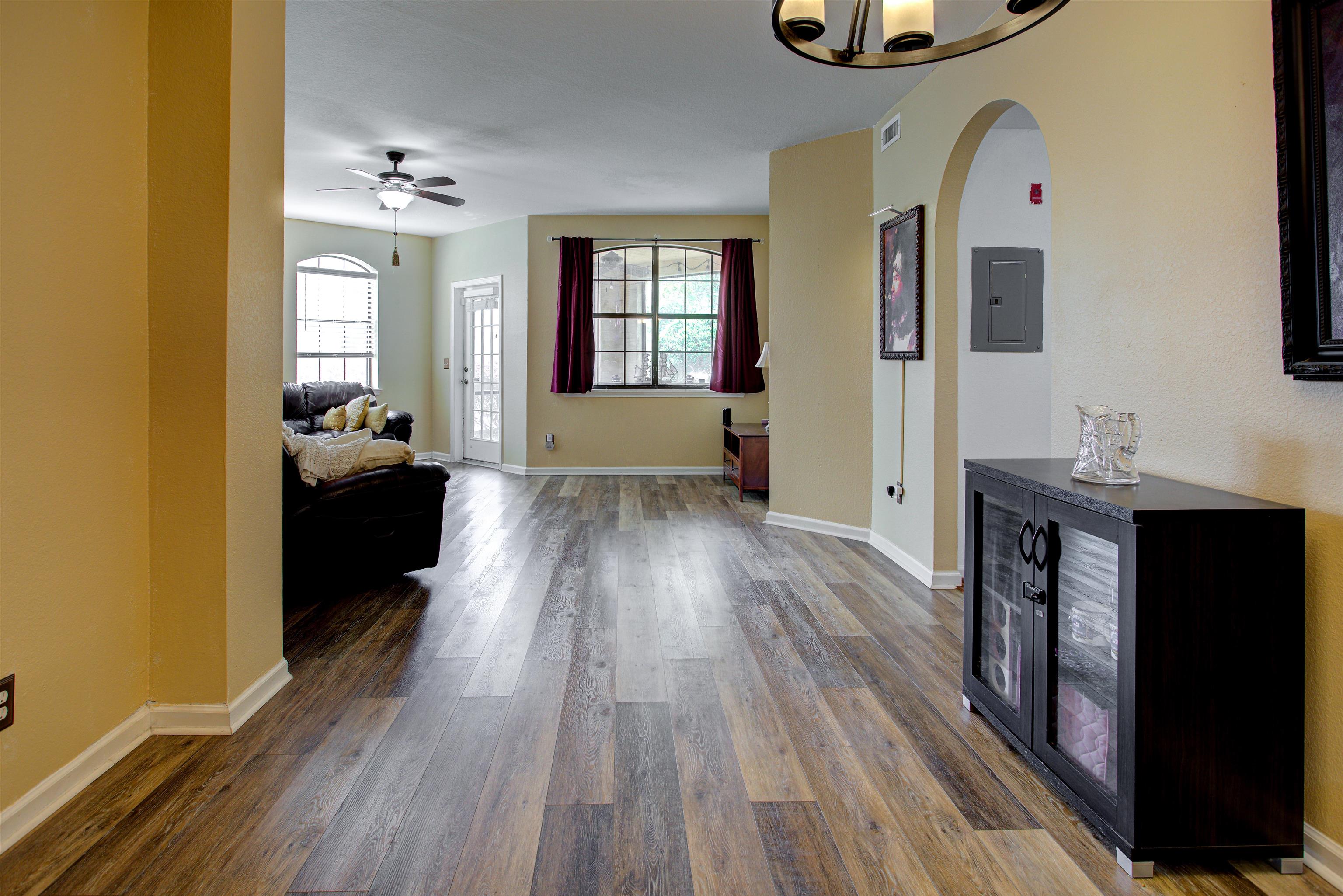 Hallway with electric panel, plenty of natural light, dark wood-style flooring, and arched walkways
