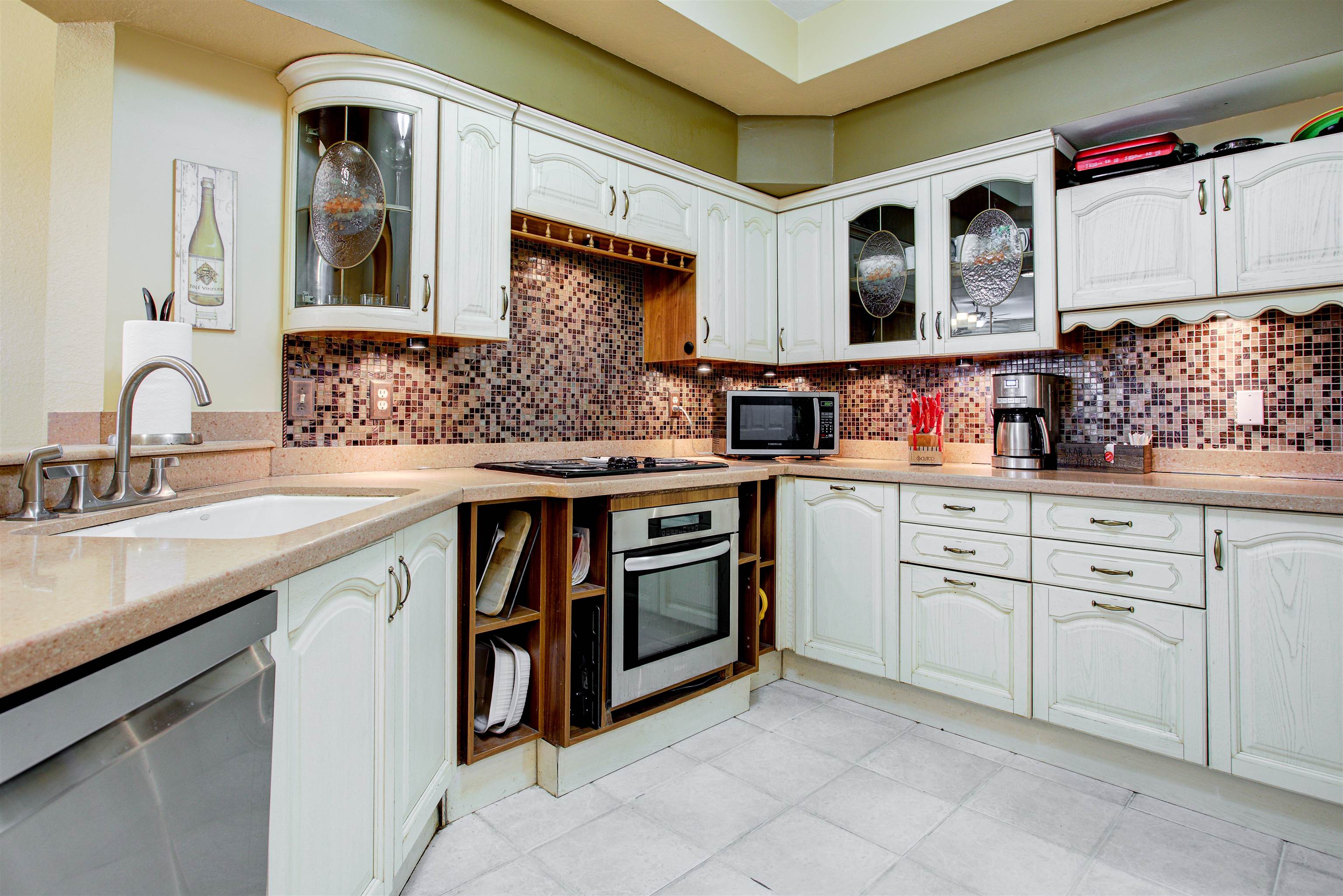 1800 Vista Cove Road St. Augustine, FL 32084 - Photo 18 of 69 Kitchen featuring glass fronted cabinets, light stone countertops, stainless steel appliances, and white cabinets