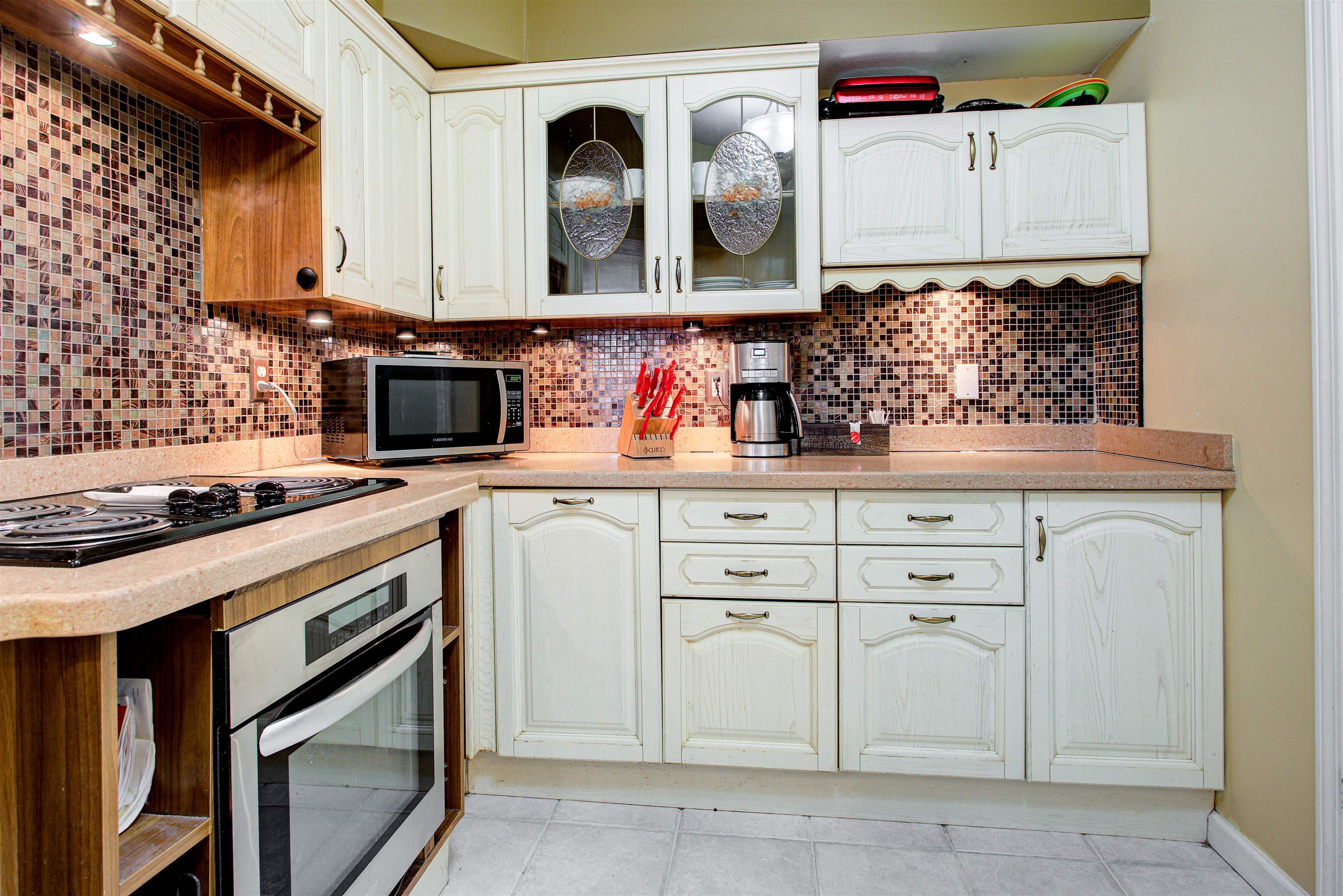 1800 Vista Cove Road St. Augustine, FL 32084 - Photo 21 of 69 Kitchen featuring stainless steel appliances, glass insert cabinets, white cabinets, and light tile patterned floors