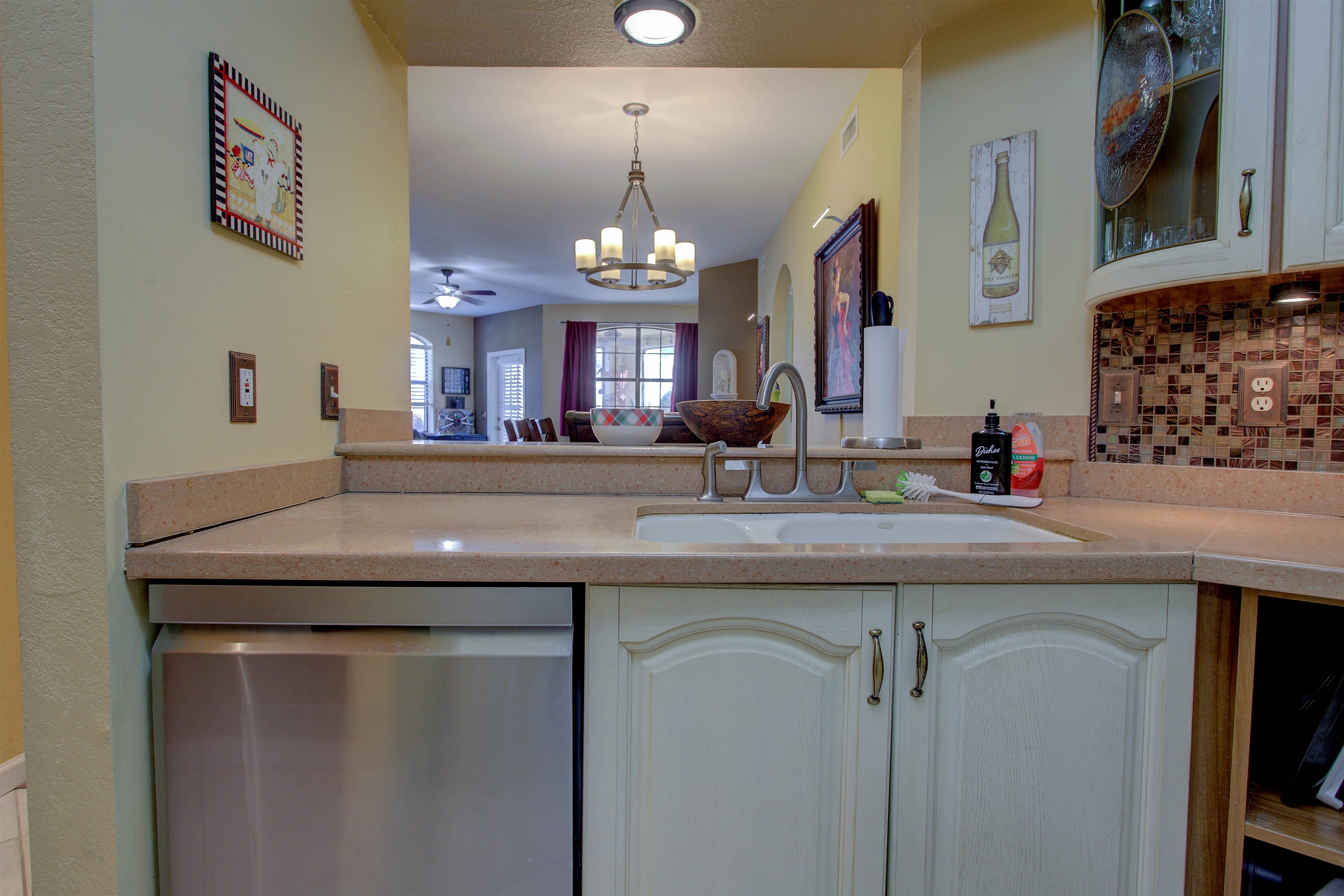 1800 Vista Cove Road St. Augustine, FL 32084 - Photo 23 of 58 Kitchen with dishwasher, a chandelier, light countertops, hanging light fixtures, and backsplash