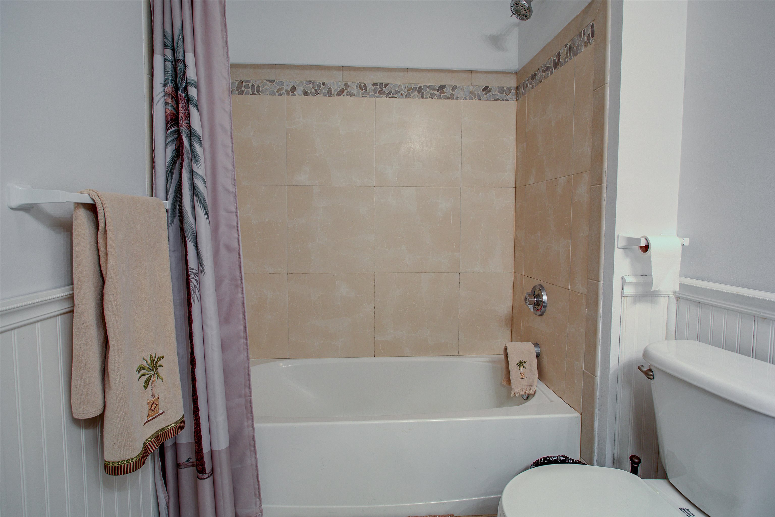 1800 Vista Cove Road St. Augustine, FL 32084 - Photo 38 of 69 Bathroom featuring wainscoting, a decorative wall, and shower / bath combo with shower curtain