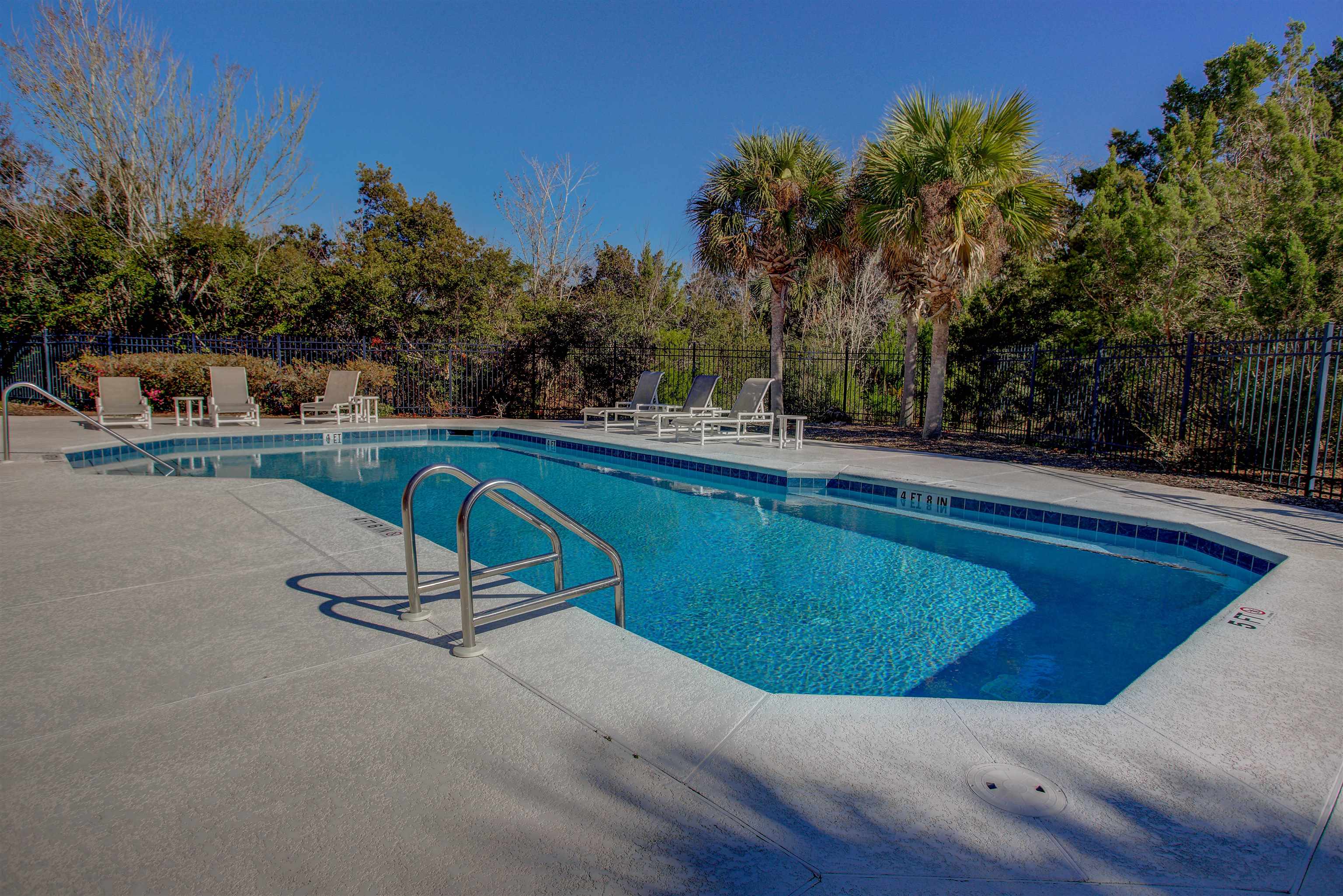 1800 Vista Cove Road St. Augustine, FL 32084 - Photo 55 of 58 a view of a swimming pool with a chair and trees in the background