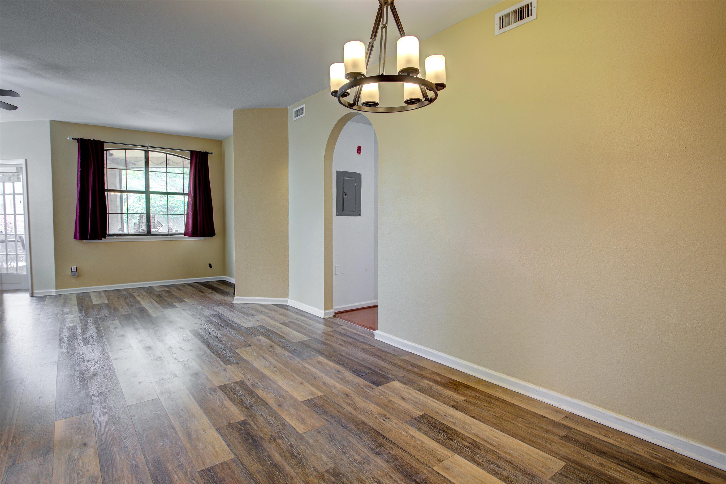 1800 Vista Cove Road St. Augustine, FL 32084 - Photo 6 of 69 Empty room featuring arched walkways, dark wood-style floors, electric panel, and suspended lighting