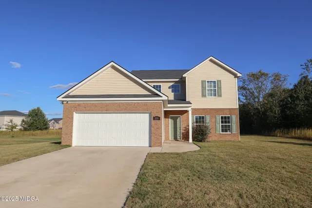 a front view of a house with a yard and garage