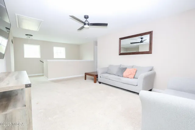 a living room with furniture and a ceiling fan
