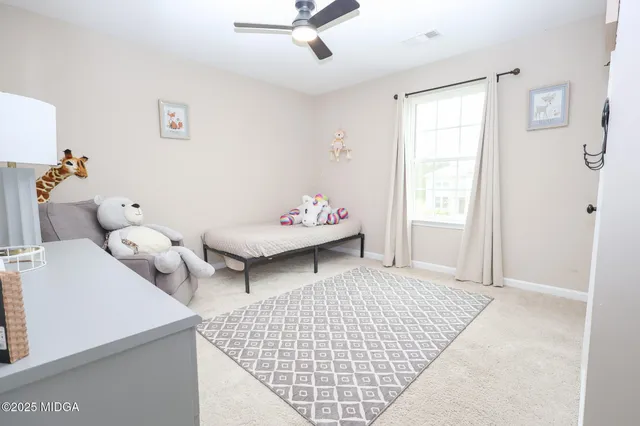 a living room with baby crib furniture and a window