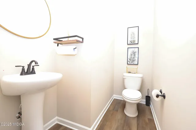 a bathroom with a sink a toilet and a mirror