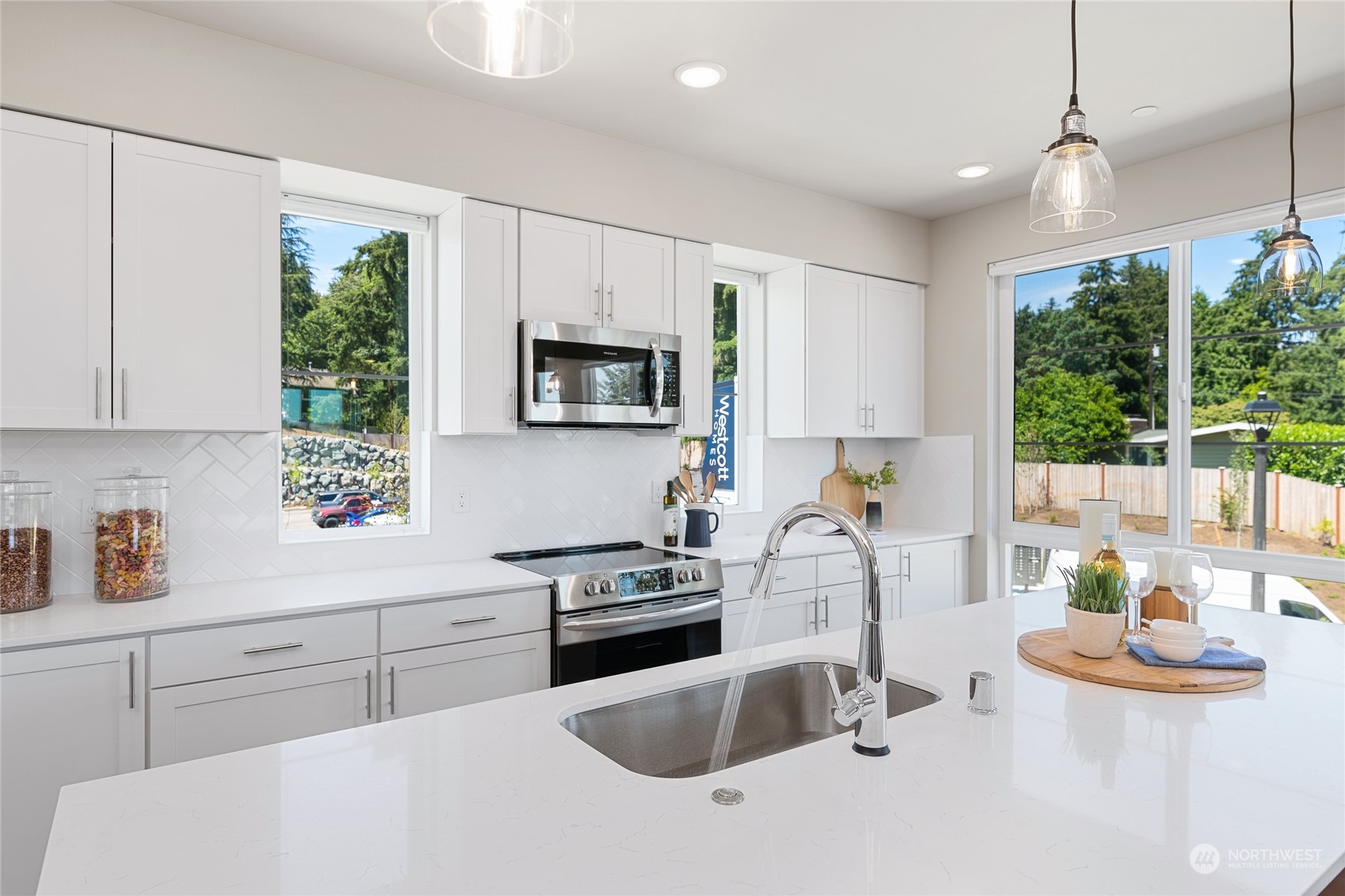 a kitchen with stainless steel appliances granite countertop a sink stove and white cabinets with wooden floor