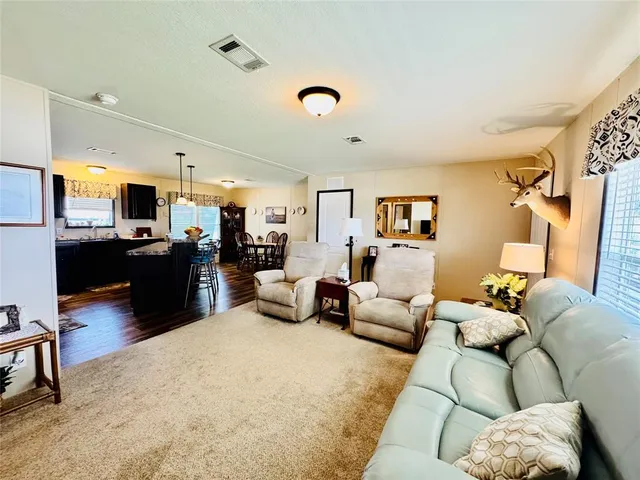 a living room with furniture and kitchen view