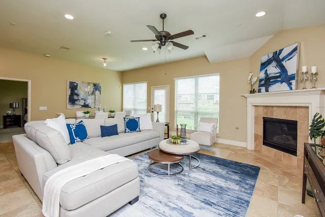 a living room with furniture a fireplace and a large window