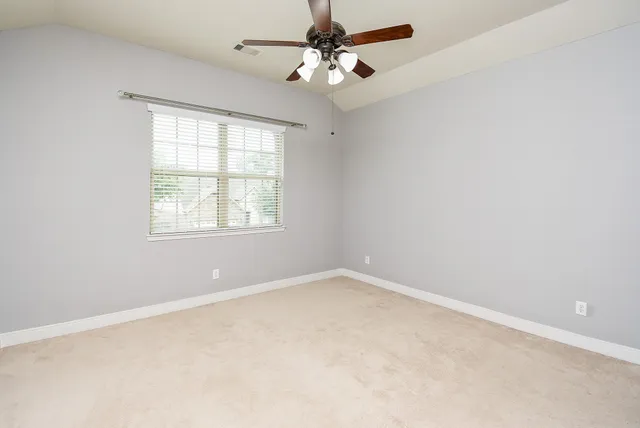 an empty room with a window and a fan
