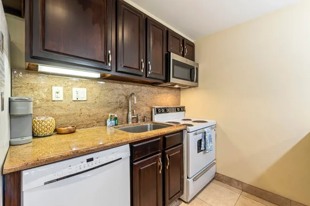 a kitchen with stainless steel appliances granite countertop a sink and a stove